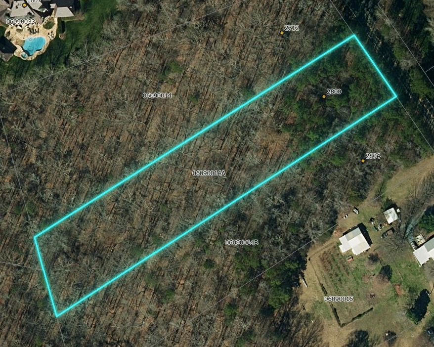 Aerial map view of a wooded vacant lot with cyan boundary outline and parcel ID labels