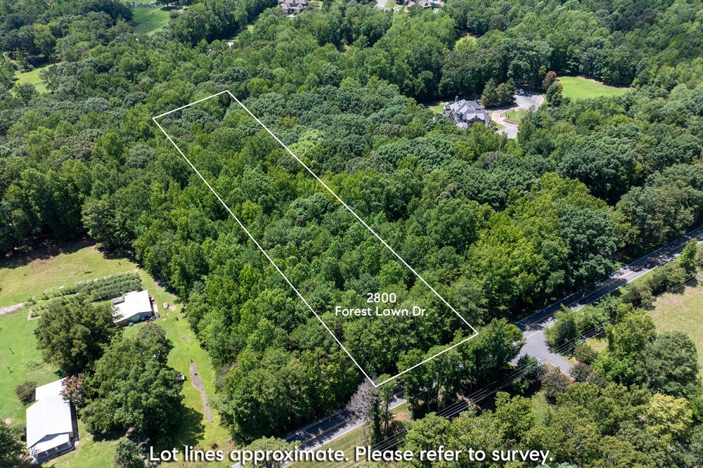 Aerial view of wooded vacant lot at 2800 Forest Lawn Dr with marked boundaries and road access nearby
