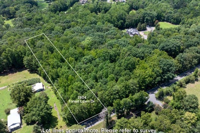 Aerial view of wooded vacant lot at 2804 Forest Lawn Dr with marked boundaries and road access nearby