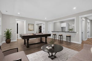 Finished basement rec room with pool table, wet bar, hardwood floors, and seating area