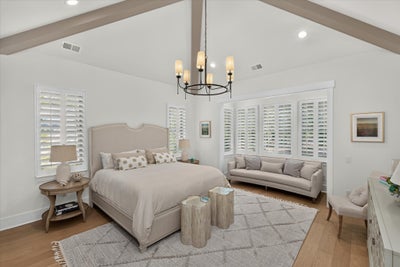 Spacious master bedroom with vaulted beamed ceiling, chandelier, plantation shutters, and hardwood floors