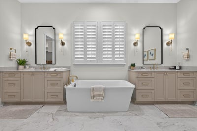 Master bathroom with freestanding soaking tub, dual vanities, and marble tile floors