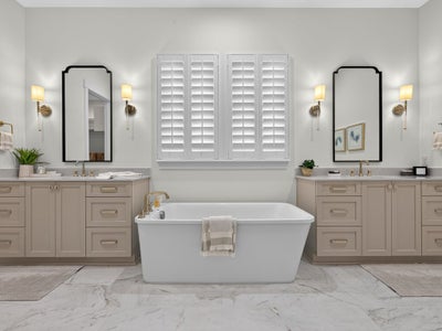 Master bathroom with freestanding soaking tub, dual vanities, marble tile floors, and plantation shutters