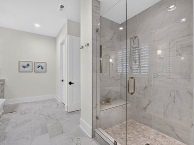 Bathroom with glass-enclosed walk-in shower featuring marble tile walls, built-in bench, and marble floor throughout