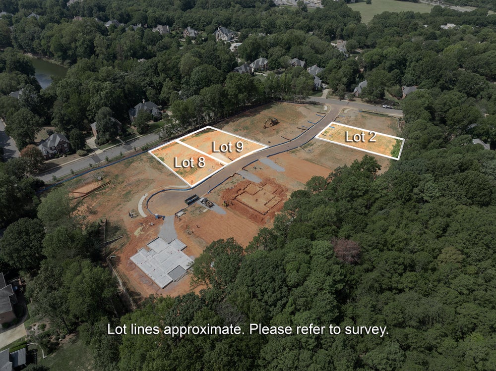 Aerial view of residential subdivision under development with lots 2, 8, and 9 marked, surrounded by trees and existing homes.